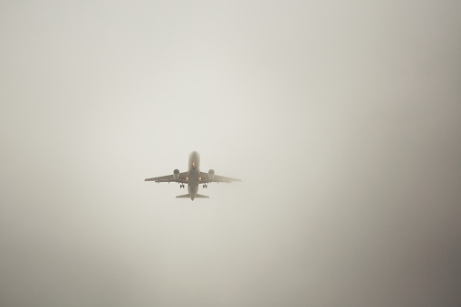 The airplane is landing during bad weather in thick fog