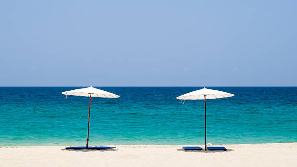 istock White beach umbrella on a sunny day against sea background. 622429580