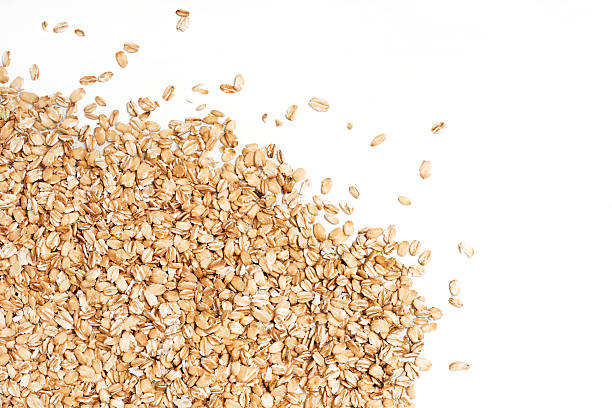Oat flakes scattered on white background. stock photo