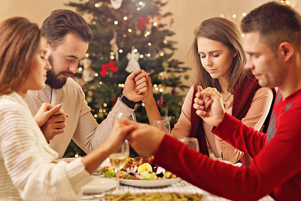 istock Group of friends praying over Christmas table 622431280