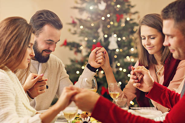 istock Group of friends praying over Christmas table 622431622