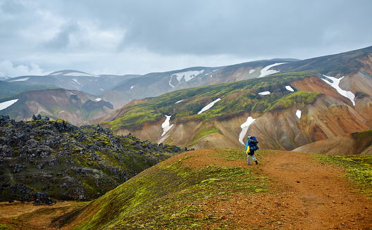 hiker on the trail in the Islandic mountains. Trek in National Park Landmannalaugar, Iceland.