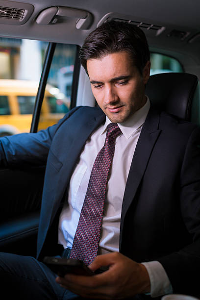 istock Man looking at phone in car 622441110