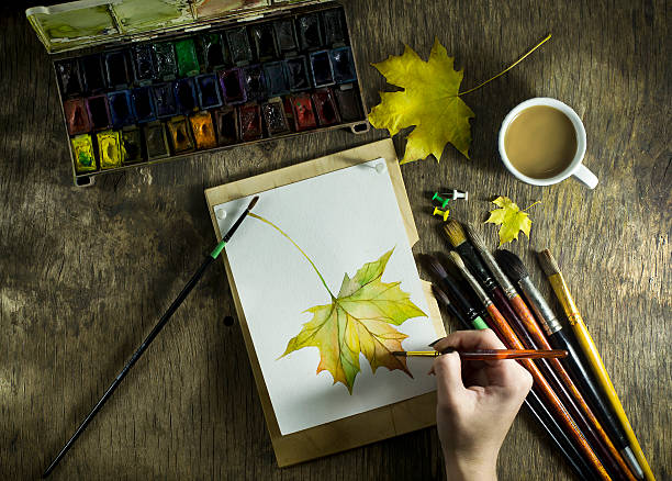 istock The hand young girl which draws sketch autumn leaf. 622441680