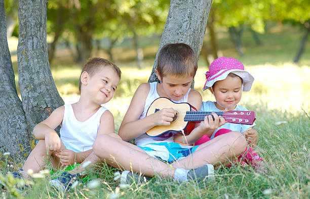 istock Brothers play guitar and sing in garden 622444298