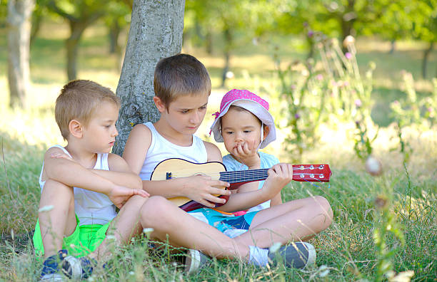 istock Brothers play guitar and sing in the garden 622444422