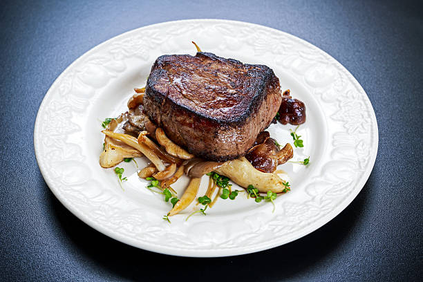 istock Tasty Beef Mignon steak with mushrooms and herbs on plate. 622445194