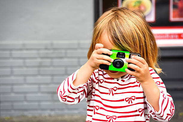Caucasian Little girl taking a picture with a disposable camera