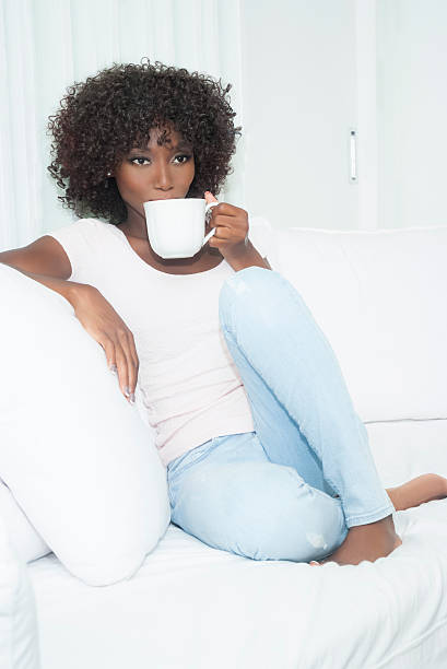 istock Brown skin woman sitting on white couch 622447902