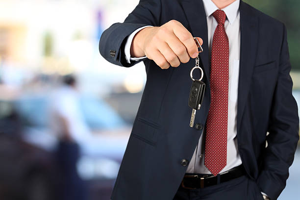 istock Successful businessman offering a car key. Driver's hand showing key 622448474