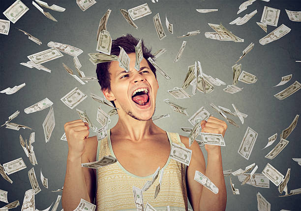 istock man celebrates success under money rain falling down dollars 622448636