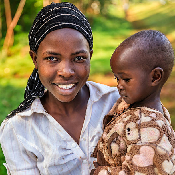 若いアフリカ人女性保持彼女のベビー、ケニア、東アフリカ - africa child village smiling ストックフォトと画像