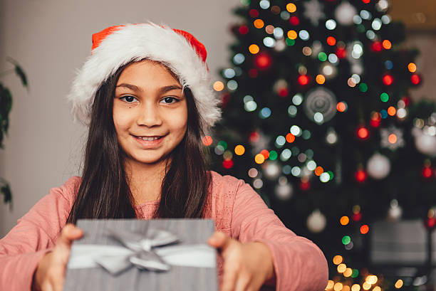 Girl with santa hat holding christmas gift