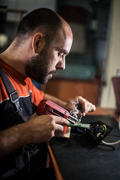 istock Repairman working in workshop and soldering electric board 622458836