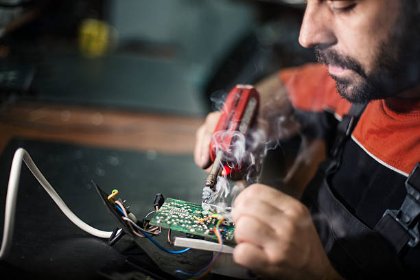 istock Repairman working in workshop and soldering electric board 622458934