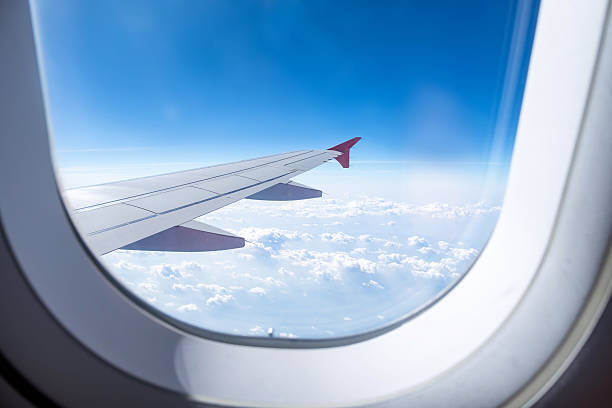 Close up Airplane window with airplane wing stock photo