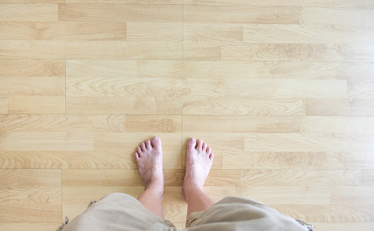 Top view,barefoot stand on wood parquet,Leave space for adding your content.