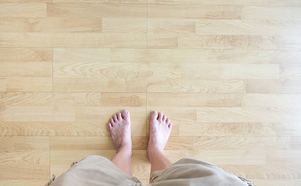 Top view,barefoot stand on wood parquet Top view,barefoot stand on wood parquet,Leave space for adding your content. Barefoot stock pictures, royalty-free photos & images