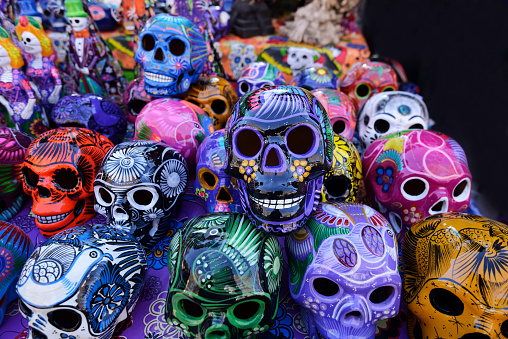 Traditional mexican day of the dead souvenir ceramic skulls at market stall.