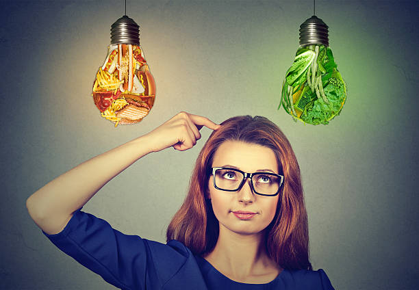 istock Woman thinking looking up at junk food vegetables lightbulbs 622518280
