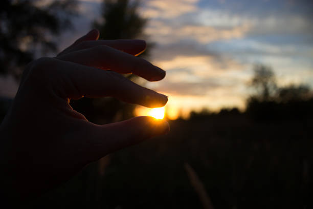 istock hand trying to hold the sun, 622518424