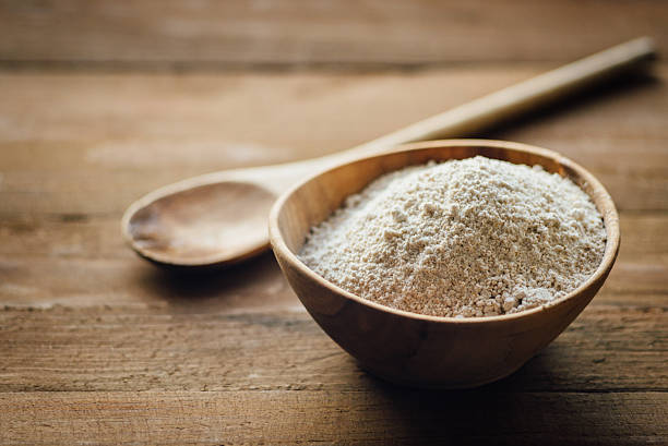 Oat flour in old wooden bowl Oat flour in old wooden bowl on dark wooden background wholegrain flour stock pictures, royalty-free photos & images