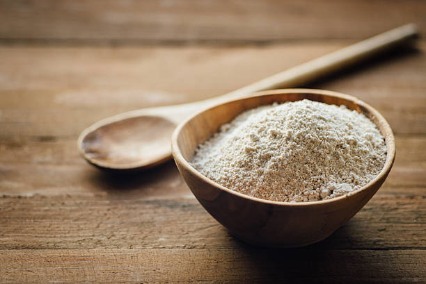 oat flour in old wooden bowl - ground flour white heap imagens e fotografias de stock