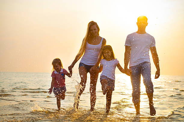 istock Happy young family having fun running on beach at sunset. 622527662