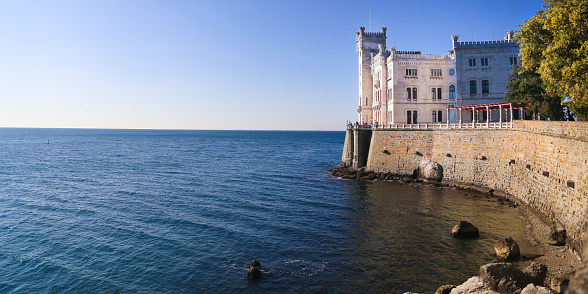 Trieste, Italy - October 27, 2016: Miramare Castle (Italian: Castello di Miramare; German: Schloss Miramar; Slovene: Grad Miramar) is a 19th-century castle on the Gulf of Trieste near Trieste, Italy. It was built from 1856 to 1860 for Austrian Archduke Ferdinand Maximilian and his wife, Charlotte of Belgium, later Emperor Maximilian I and Empress Carlota of Mexico, based on a design by Carl Junker.