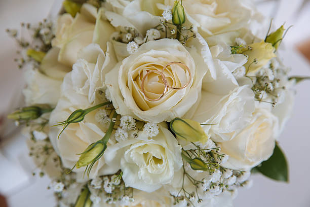 istock Gold rings on wedding bouquet with white roses 622527750