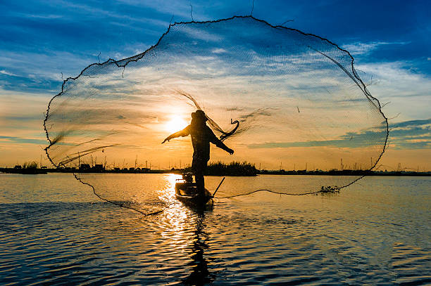 istock Silhouette of a fisherman throwing his net with sunset 622531520