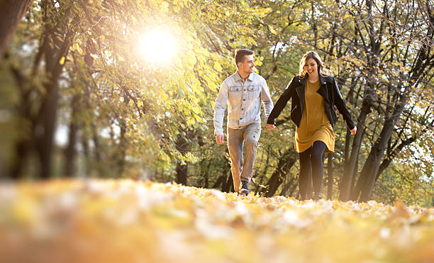 istock Happy young romantic couple walking on fallen leaves 622538064