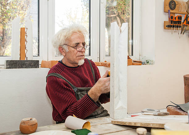 sculptor in his studio handles a piece of marble stock photo