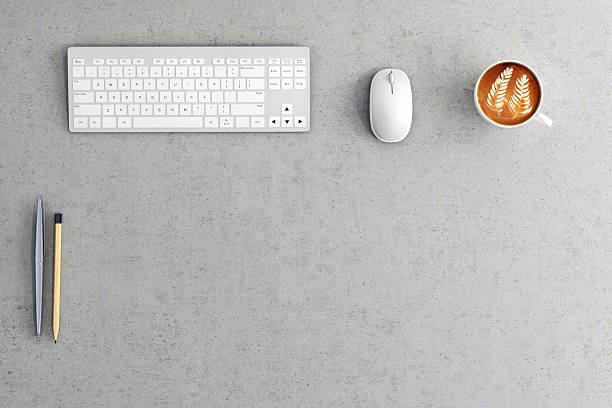 Close up of a business office desk Close knolling top view of an office desk with a keyboard and mouse, coffee cup, Horizontal composition of a working business with clean bottom part of a photo for embedding aditional design. Horizontal composition messy vs clean desk stock pictures, royalty-free photos & images