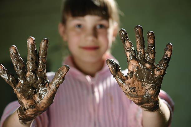 istock girl with dirty hands on a dark background. 622544562