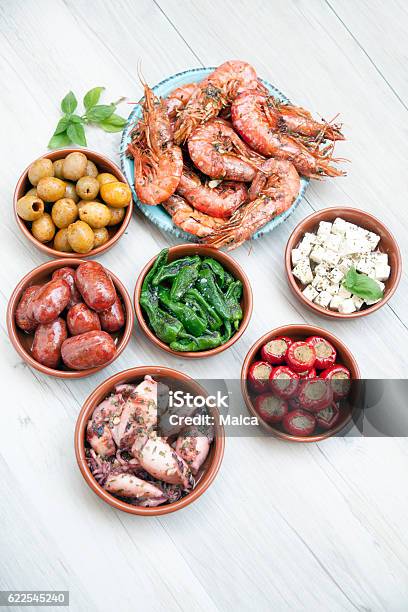 Choice Of Tasty Spanish Tapas On A Wooeden Table Stock Photo - Download Image Now - Tapas, Garlic, High Angle View