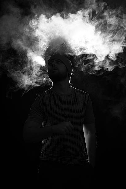 istock Men with beard vaping on black background in hat 622547174