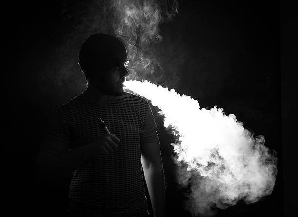 istock Men with beard vaping on black background in hat 622547268