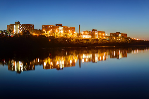 New Brunswick, New Jersey, USA - October 4, 2016: Night view of the Rutgers University campus Halls reflecting on a calm Raritan River