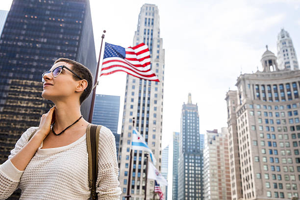 istock Young woman in downtown Chicago against US flag 622549018