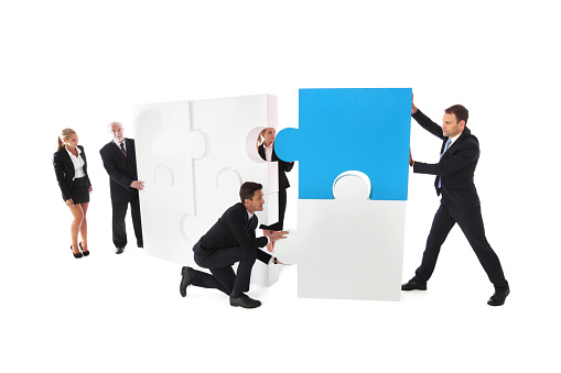 Business teamwork building big puzzle isolated on white background