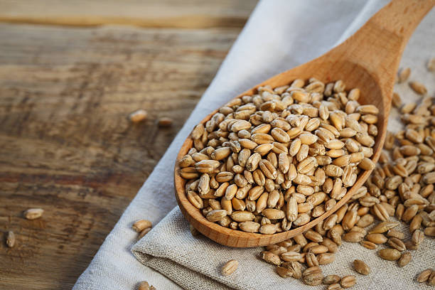 istock Wheat in a wooden spoon with space for text, close-up 622768272