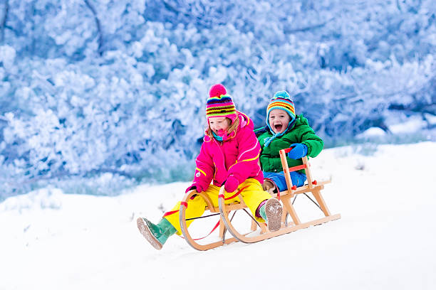 istock Kids having fun on sleigh ride in mountains in winter 622772008