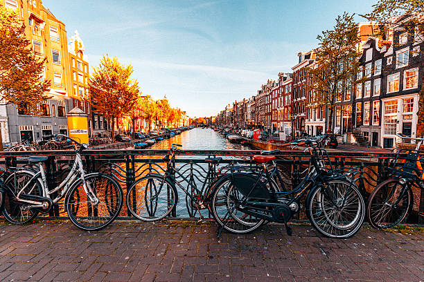 vélos garés sur un pont à amsterdam - amsterdam photos et images de collection