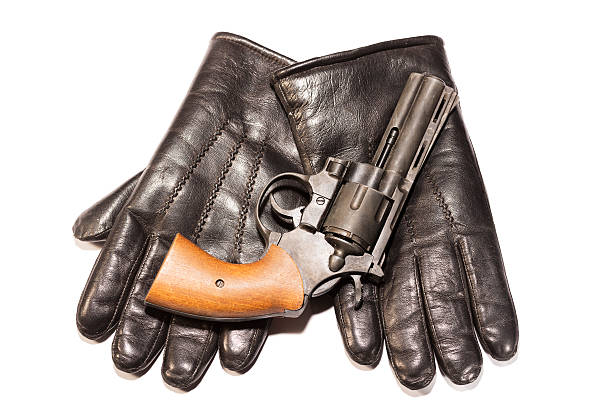 istock Mafia concept. Black gun on leather gloves isolated 622780716