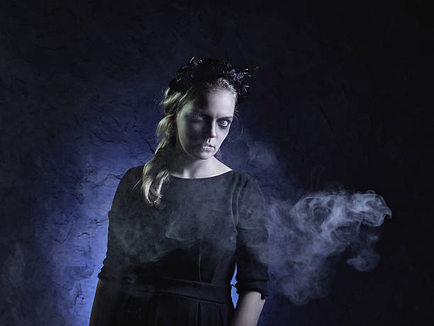 Dark portrait of evil witch in smoke stock photo