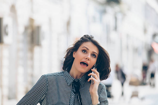 istock Young woman talking on phone on street 622788642
