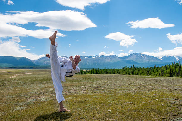 Man in white kimono and black belt training karate on