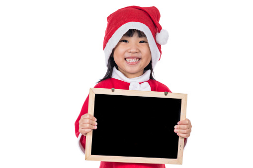 Happy Asian Chinese little santa girl holding blank board in isolated white background