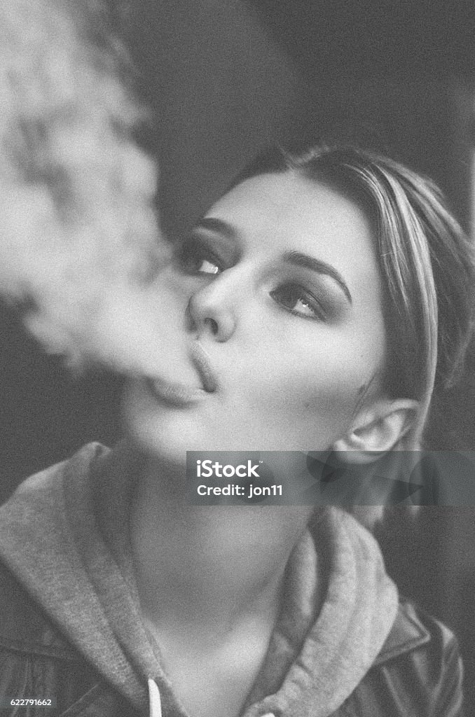 Young woman smoking Electronic Cigarette Portrait of a Young Woman smoking electronic cigarette. Black and white post processing Black And White Stock Photo